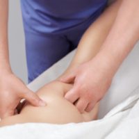 The masseur makes Anti-cellulite massage on the buttock and thighs of the patient. Treatment of excess weight.